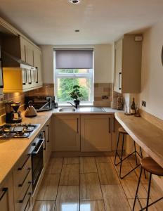 MirfieldApartment 11, Mirfield, West Yorkshire的厨房配有棕色橱柜、水槽和窗户。