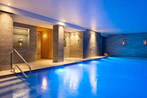 福勒恩RockyPop Flaine Appartements & Spa的蓝色灯光的酒店游泳池