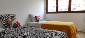 马赛Appartement vacances Marseille的客房设有两张床、一张沙发和一个窗口。