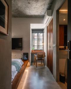 曼谷Tamni的卧室配有床、椅子和窗户。