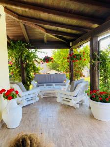 福尔梅洛Chanel Garden Relaxation Home的庭院配有白色的椅子、桌子和鲜花