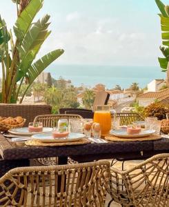 马拉加Luxury B&B Villa Tauro的露台上的桌子上摆放着食物和橙汁