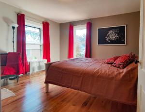 奥克帕克Historic Oak Park Home for 6 / Hemingway District的一间卧室配有一张带红色窗帘的大床