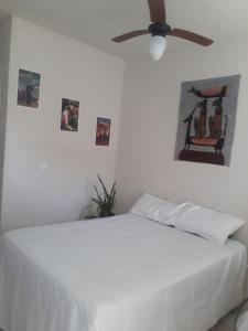 TamoiosCasa Verde的卧室配有白色的床和吊扇