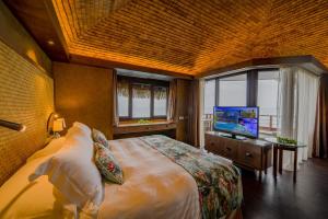 帕皮提大溪地洲际spa度假酒店的一间卧室配有一张床,并在一间客房内配有电视。