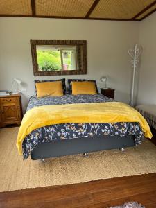 OtakiSundari Retreat的一间卧室配有一张带黄色毯子和镜子的床
