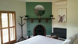 巴林布莱克伍德山谷套房住宿加早餐旅馆的卧室设有壁炉和墙上的镜子