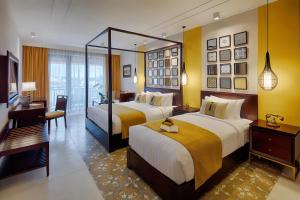 会安Allegro Hoi An . A Little Luxury Hotel & Spa的酒店客房配有两张床和一张书桌