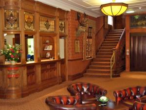 沙普贝斯特韦斯特夏鹏威尔斯酒店的大堂设有皮椅和楼梯间
