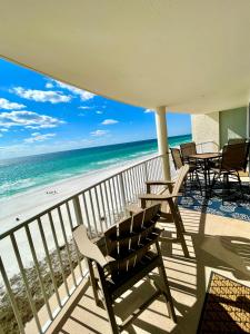 巴拿马城海滩Emerald Bay Escape的一个带桌椅的阳台和海滩