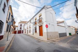 安特克拉CASA EL RINCONCITO的一条有白色建筑和红站标志的街道