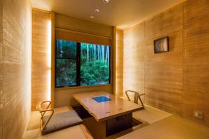 伊东Toushinan Komeya的客房设有桌椅和窗户。