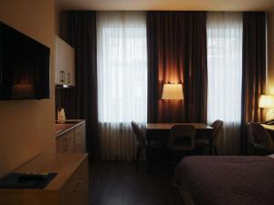 圣彼得堡伊格尔克宾馆的配有一张床、一张桌子和一张桌子的酒店客房