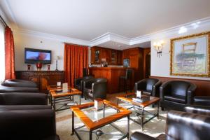 奥利特埃尔朱格拉酒店的一间设有黑色皮革椅子和桌子的等候室