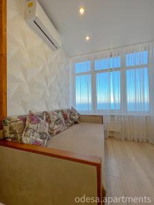 敖德萨Sea View Sky 15 Апартаменти в Одесі的客厅设有一张床和两个窗户。
