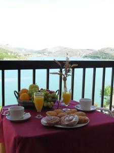 努瓦洛斯拉斯茹姆巴斯酒店的阳台上的桌子上摆着早餐食品和饮料