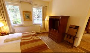 霍恩-巴特迈恩贝格西尔本穆勒森林酒店的一间卧室配有一张床和一台平面电视