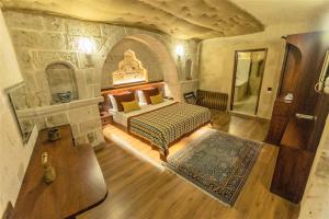 乌奇希萨尔Mimi Cappadocia Luxury Cave Hotel的卧室享有高空美景,配有一张床和地毯