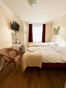 伦敦墨尔本别墅酒店的酒店客房设有两张床和电视。
