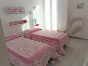 托尔博莱Garden Belvedere B&B的客房内的两张床和粉红色的被褥
