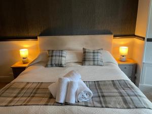 鲍内斯温德米尔皇家橡树旅馆的一间卧室配有一张床,上面有两条毛巾