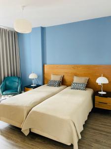 丰沙尔Ocean Cliffs Apartments的一间卧室设有一张大床和蓝色的墙壁