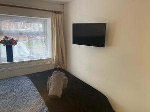 考文垂Elegant Practical onsite Cosy Studio in a quiet location的卧室配有毛巾和电视。
