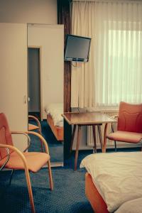 普特布斯Inselgaestehaus-Erna的配有椅子、桌子和床的房间