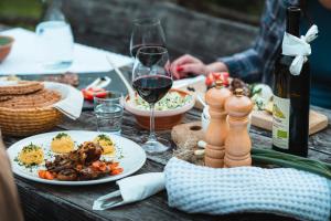 特伦塔Organic Tourist Farm Pri Plajerju的餐桌,带食物盘和一瓶葡萄酒