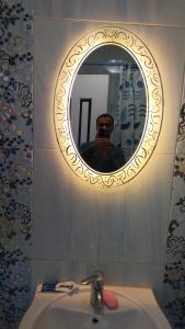 开罗Luxury Apartments的把镜子照在水槽上的人