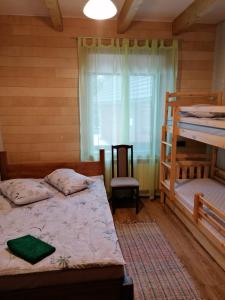 Baltais DukstgalsViesu nams Liepas的一间卧室设有两张双层床和一扇窗户。