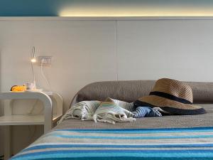切萨雷奥港FronteMare Rooms的一张带两个枕头的床和一顶帽子