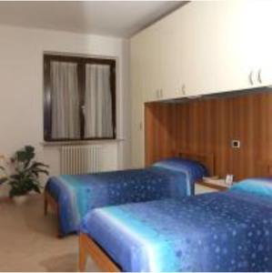 托尔托雷托Verde Mare "Appartamenti per Vacanze"的带3张蓝色床和镜子的房间