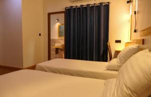 FeridhooAYIRA Maldives的酒店客房带两张床和蓝色窗帘