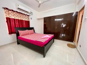 蒂鲁帕蒂TrueLife Homestays - Alamelu Avenue - Fully Furnished AC 2BHK Apartments in Tirupati - Walkable to Restaurants & Super Market - Fast WiFi - Kitchen - Easy access to Airport, Railway Station, Sri Padmavathi & Tirumala Temple的一张小床,位于一个红色窗帘的房间