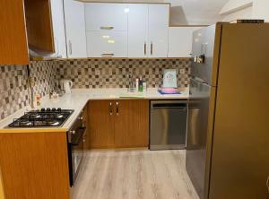 YıldırımBURSA TELEFERIK 4 1 DUPLEX apartment的厨房配有不锈钢冰箱和木制橱柜