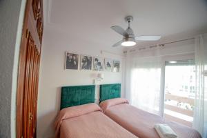 韦尔瓦"El Balcón de Huelva" lujo en pleno centro的一间卧室配有一张带粉色床单的床和一扇窗户。