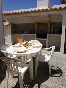 萨格里什Casa Oliveirinha - Sagres的一张白色的桌子和两把椅子,上面有食物