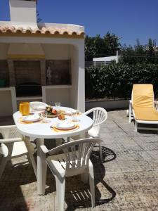 萨格里什Casa Oliveirinha - Sagres的庭院里的白色桌椅