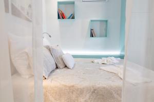 PanayíaTheoxenia Kasos Luxury Apartments的白色房间的床,墙上有书