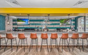 默特尔比奇Oceanfront Suite Grande Cayman 124的餐厅的酒吧,有橘子凳