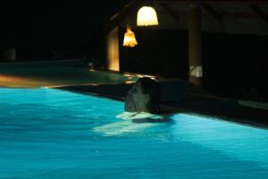 代尼耶耶Rainforest Mount Lodge的一位晚上躺在游泳池里的女人