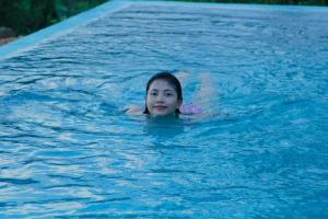 代尼耶耶Rainforest Mount Lodge的在一个游泳池游泳的年轻女孩