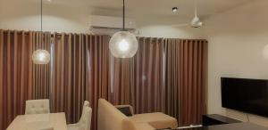 KottawaLuxe Highway Residencies的客厅配有棕色窗帘和电视