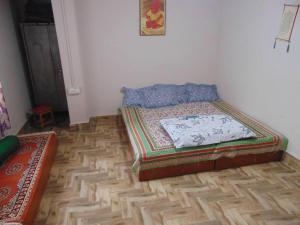 甘托克BOJO House的一间卧室配有一张床,铺有木地板