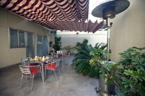 圣阿德里安-德贝索斯圣阿德里雅辞屋塔酒店的一个带桌椅和植物的庭院