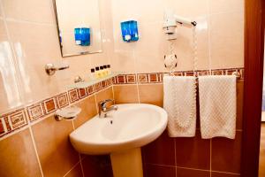 希莱Miletus Otel Şile的浴室配有盥洗盆、镜子和毛巾