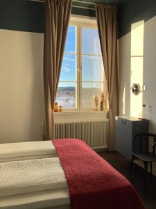 ÅmotStilleben Hotell的一间卧室设有一张床和一个大窗户