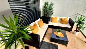 布尔诺Nobless Apartments Holedná Brno的阳台配有沙发和盆栽植物
