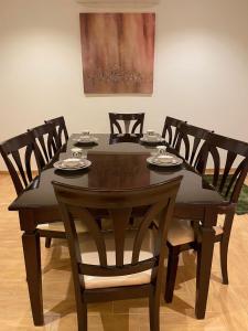 利雅德Strings Chalet的餐桌、椅子和黑桌及椅子